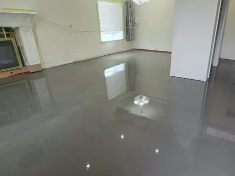 Living room with self-levelling compound poured up to a masked-off fireplace